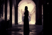 Silhouette Woman Standing In Corridor Of Historic Church