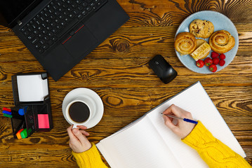 Poster - Laptop with cup of coffee on old brown wooden table. Top view to Notebook with cup of fresh coffee in home office in village.