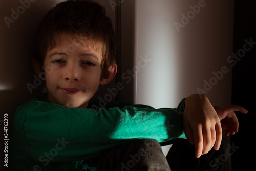 Fotografía portrait of a boy con cara de sueño mitad en sombra y mitad con luz de la Mañana