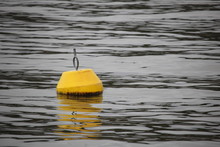 Yellow Buoy Floating In Lake
