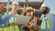 © Gorodenkoff - Diverse Team of Specialists Use Laptop Computer on Construction Site. Real Estate Building Project with Civil Engineer, Architectural Investor, Businesswoman and Worker Discussing Blueprint Plan