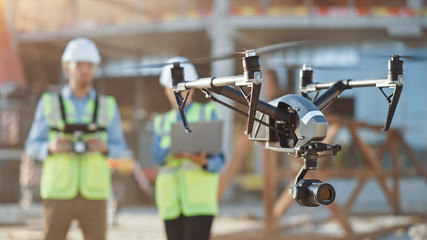 two specialists use drone on construction site. architectural engineer and safety engineering inspec