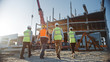 © Gorodenkoff - Diverse Team of Specialists Inspect Commercial, Industrial Building Construction Site. Real Estate Project with Civil Engineer, Investor and Worker. In the Background Crane, Skyscraper Formwork Frames