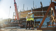 © Gorodenkoff - Two Specialists Inspect Commercial, Industrial Building Construction Site. Real Estate Project with Civil Engineer, Investor Use Laptop. In the Background Crane, Skyscraper Concrete Formwork Frames
