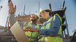 © Gorodenkoff - Two Specialists Inspect Commercial, Industrial Building Construction Site. Real Estate Project with Civil Engineer, Investor Use Laptop. In the Background Crane, Skyscraper Concrete Formwork Frames