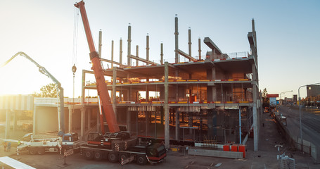 Wall Mural - Aerial View of Industrial / Commercial Property Building Construction Site. Machinery and Skyscraper Concrete Formwork Frame with in the Sunrise