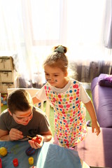 Funny kids with stained faces having fun at home in the kitchen. Brother and little sister. Funny. Creative concept. Mess at home. Normal quarantined life. Lifestyle COVID-19