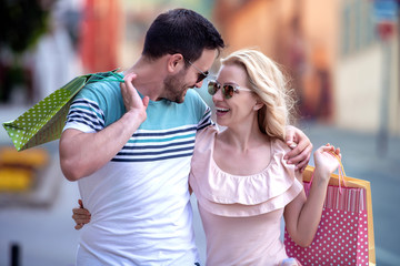 Poster - Young attractive couple with shopping bags