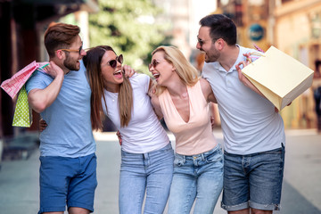 Canvas Print - Group of young friends shopping outdoors together