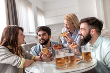 Wall Mural - Group of friends enjoying pizza and beer.