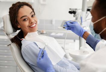 Wall Mural - Pretty black woman in dentist chair ready for check up