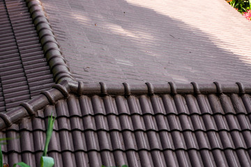 Wall Mural - Brown natural tile roof. Modern types of roofing materials. Roof of the house, Natural roof tile against the blue sky. Building.