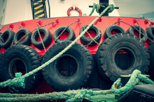 Old Car Tires On Board A Ship. Rubber Wheels Protect The Boat From Impact. Steel Lining Of The Side Of The Tugboat.