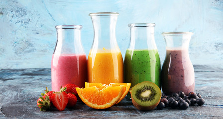 Wall Mural - Assortment of fruit smoothies in glass bottles. Fresh organic Smoothie ingredients. Smoothies for health or detox diet food