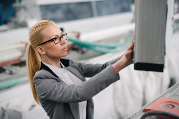 Wall Mural - Factory manager in inspection of manufacturing. Woman in factory.	