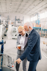 Colleagues working on project. Team of architects discussing business in factory.	