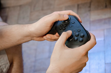 Close up on male hands holding a joystick to video game play