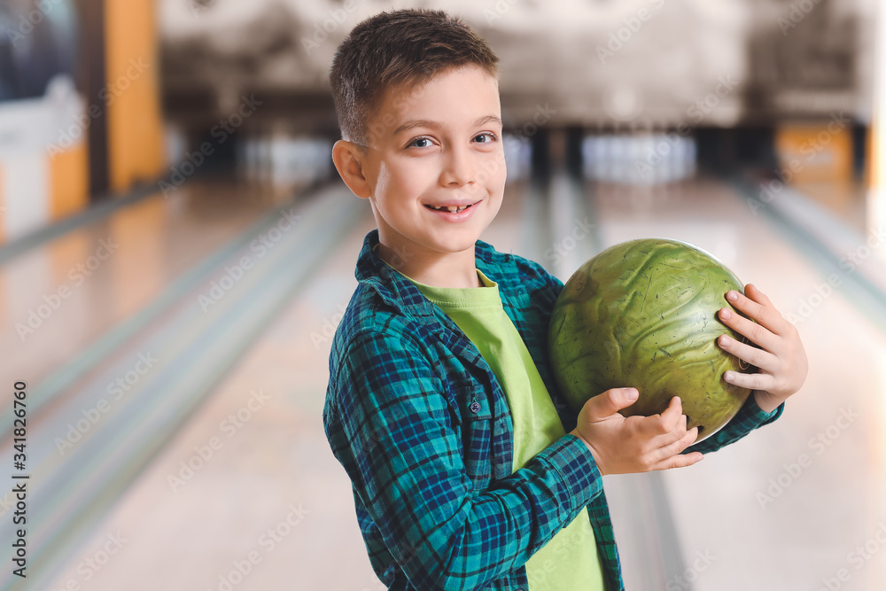 Little boy playing bowling in club