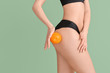 © Pixel-Shot - Young woman with orange fruit on color background. Concept of cellulite