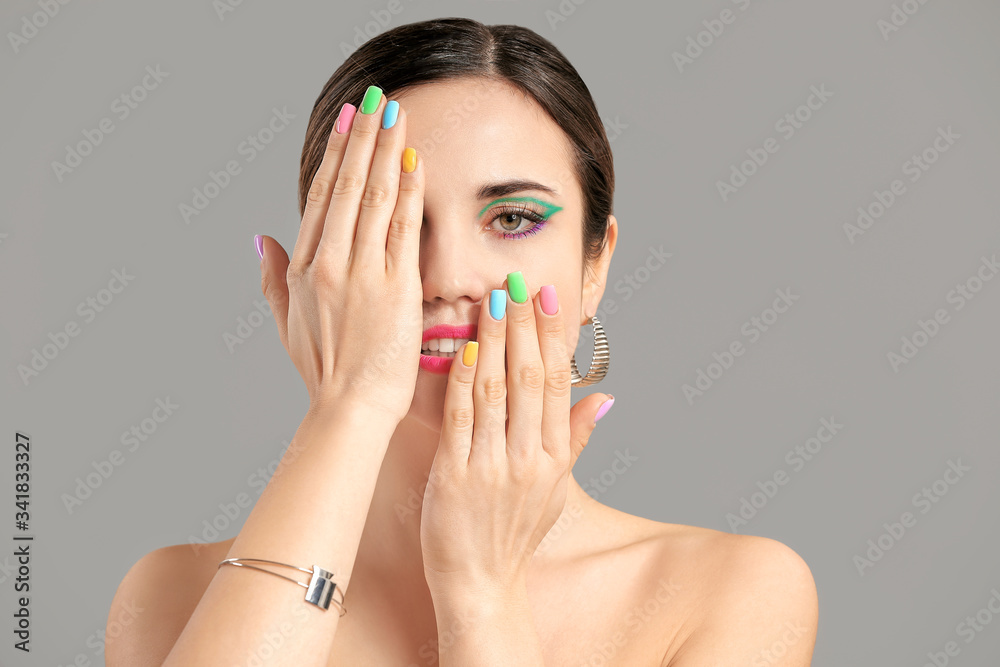Young woman with beautiful manicure on grey background