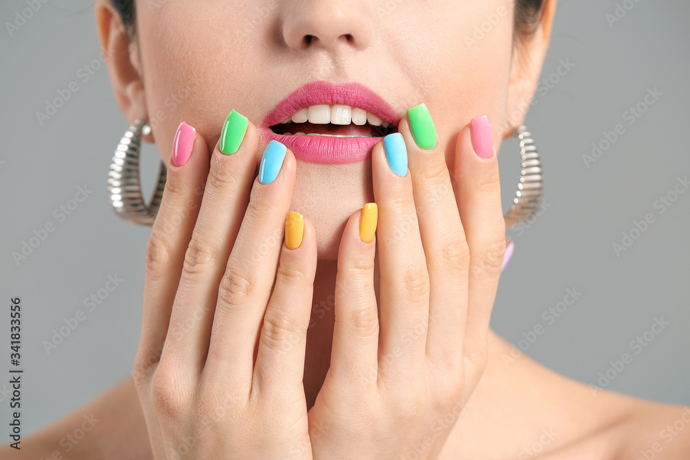 Young woman with beautiful manicure on grey background, closeup
