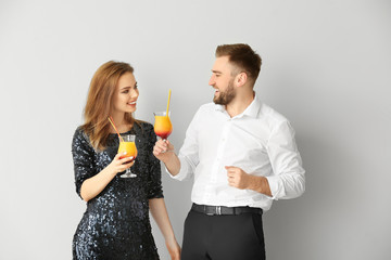 Sticker - Happy couple with cocktails on grey background