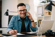 © JustLife - Businessman in office. Handsome man talking on phone at work