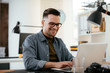 © JustLife - Businessman in office. Handsome man working on lap top.