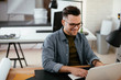 © JustLife - Businessman in office. Handsome man working on lap top.