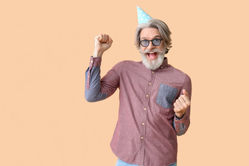 Senior man celebrating Birthday on color background