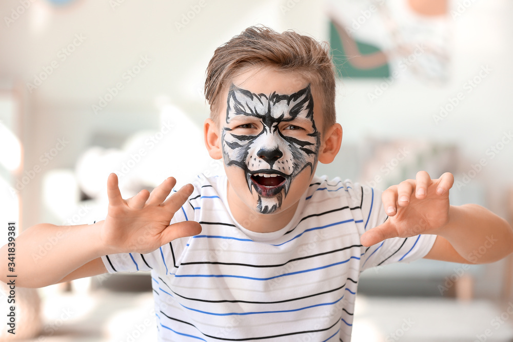 Funny little boy with face painting at home