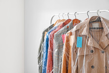 Rack With Clothes After Dry-cleaning On Light Background