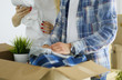 © lenets_tan - A just married couple unpacking boxes and moving into a new home. Positive emotion.