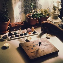 Cropped Image Of Hand Holding Pendulum At Home