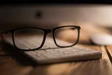 Glasses for sight and vision correction and protection from computer on the wooden table on the keyboard