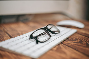 Poster - Glasses for sight and vision correction and protection from computer on the wooden table on the keyboard