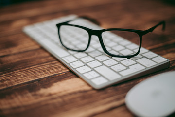 Wall Mural - Glasses for sight and vision correction and protection from computer on the wooden table on the keyboard