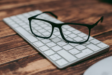 Glasses for sight and vision correction and protection from computer on the wooden table on the keyboard