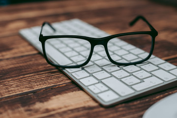 Glasses for sight and vision correction and protection from computer on the wooden table on the keyboard