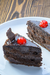 two chocolate brownie cakes with red berries on a white dish