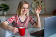 © FOTO_STOCKER - Happy woman using laptop pc for video call friends and parents, smiling girl sitting at home kitchen fun greeting online by computer webcam making videocall.