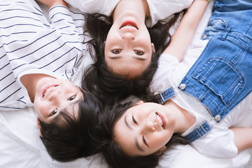 Poster - Happy Asian family smiling mother, son & daughter on bed in bedroom. Mom, son & daughter have fun together at home. Love relationship or bonding between mum and children. People lifestyle concept