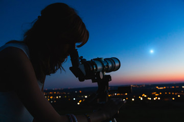 Wall Mural - silhouette of a woman and telescope with twilight sky.