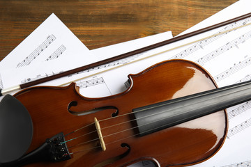 Poster - Beautiful violin, bow and note sheets on wooden table, flat lay