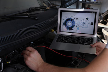 Poster - Mechanic with laptop doing car diagnostic at automobile repair shop, closeup