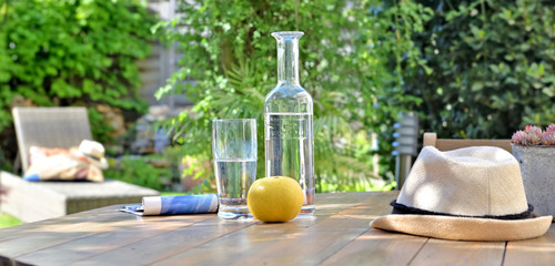 close on drink and apple on a wooden table in garden  background in summer