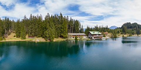 Wall Mural - Idyllic tranquil Lake Frauensee in spring embedded to forest and cloudy sky