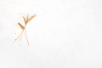 Wall Mural - Wheat ears on the white textured table background