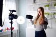 © artiemedvedev - Fashion blogger woman in jeans and turtleneck showing fashionable caps on camera. Stylist influencer girl showing trendy hats filming vlog episode for her video channel. Opinion leader sets trends.