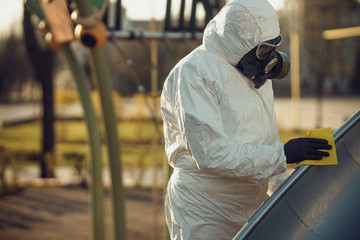 Wall Mural - Cleaning and Disinfection on the playground in the sity complex amid the coronavirus epidemic Teams for disinfection efforts Infection prevention and control of epidemic Protective suit and mask